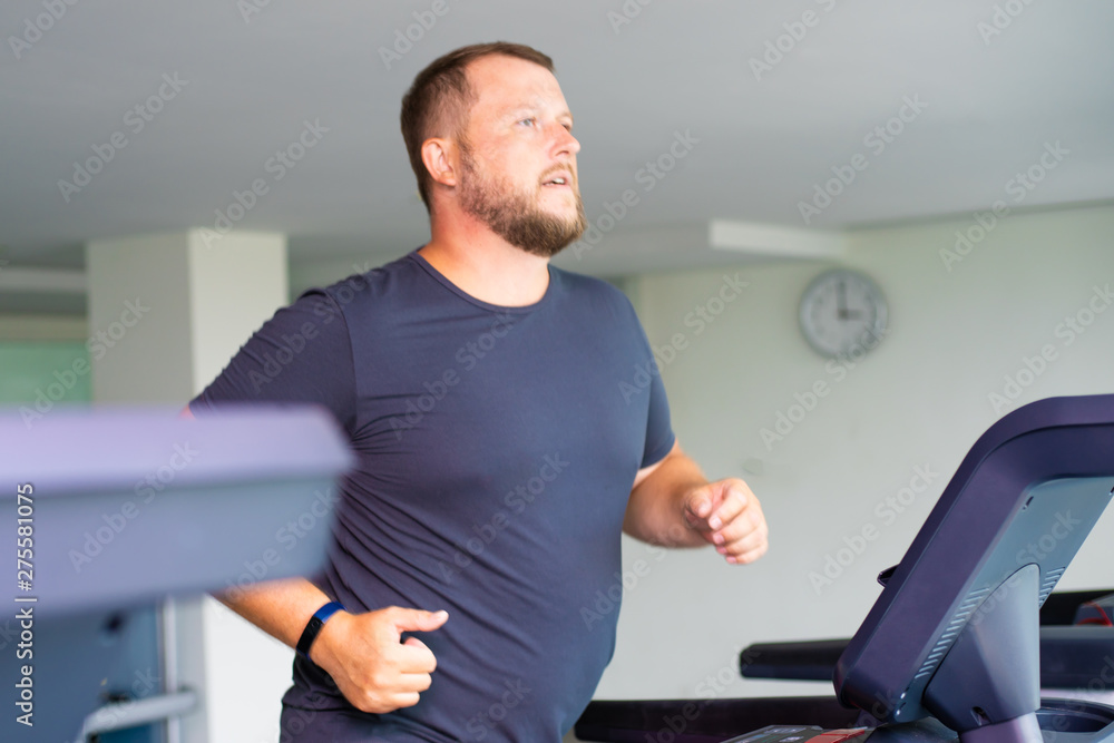chubby man walking on running track, warming up on gym treadmill. chubby man walking on running track, warming up on gym treadmill.