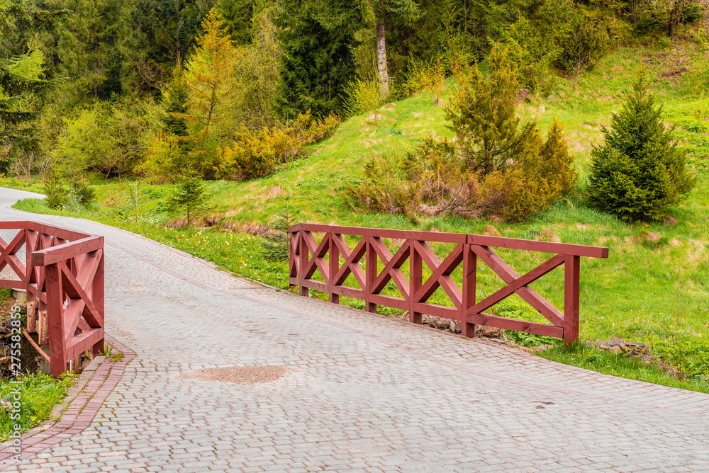 The beautiful wooden bridge through the forest mountain river