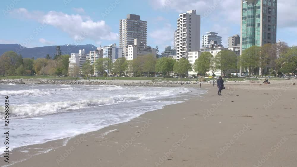 Camera pan to reveal waves breaking on the shore of a windy beach. Camera pan to reveal waves breaking on the shore of a windy beach.