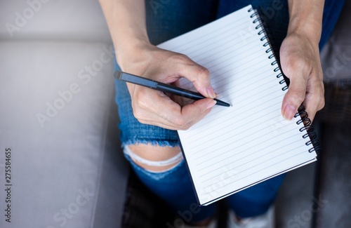 Women holding a pen writing a notebook. Recording and business concept.
