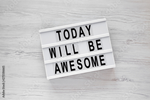 'Today will be awesome' words on a lightbox over white wooden background, overhead view. Flat lay, from above, top view.