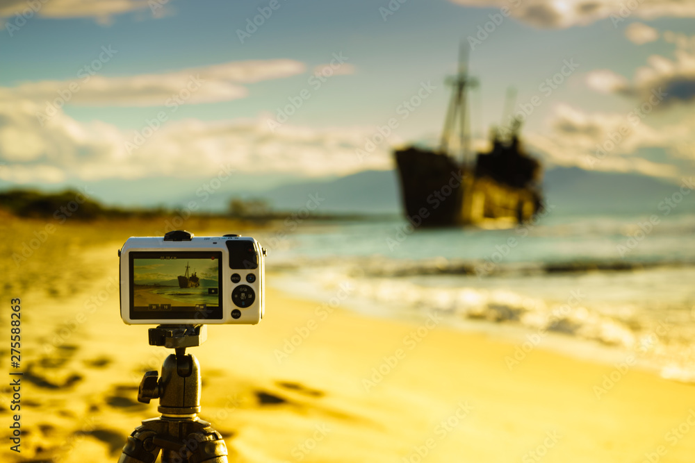 Camera on tripod and shipwreck - obrazy, fototapety, plakaty 