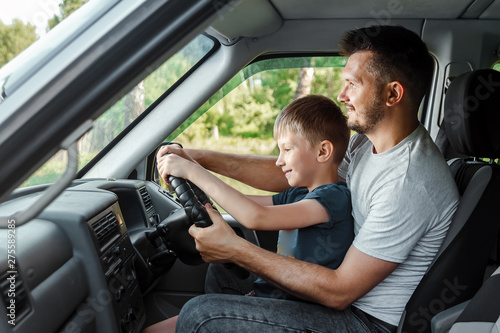 Man, father teaches little son to drive on the road. Parents and children, dad and son