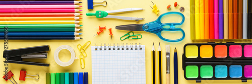 Set of school stationery and supplies on yellow background.