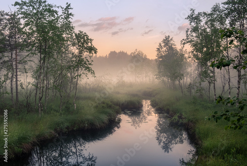 Idyllic river view with tranquil and foggy sunset at summer night in wetland, Finland