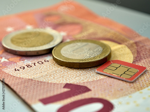 Close up of view to 10 euro banknote with two and one euro coins and sim card.