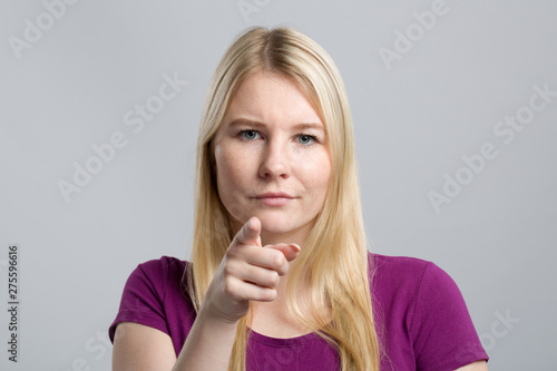 young woman in pink shirt pointing directly