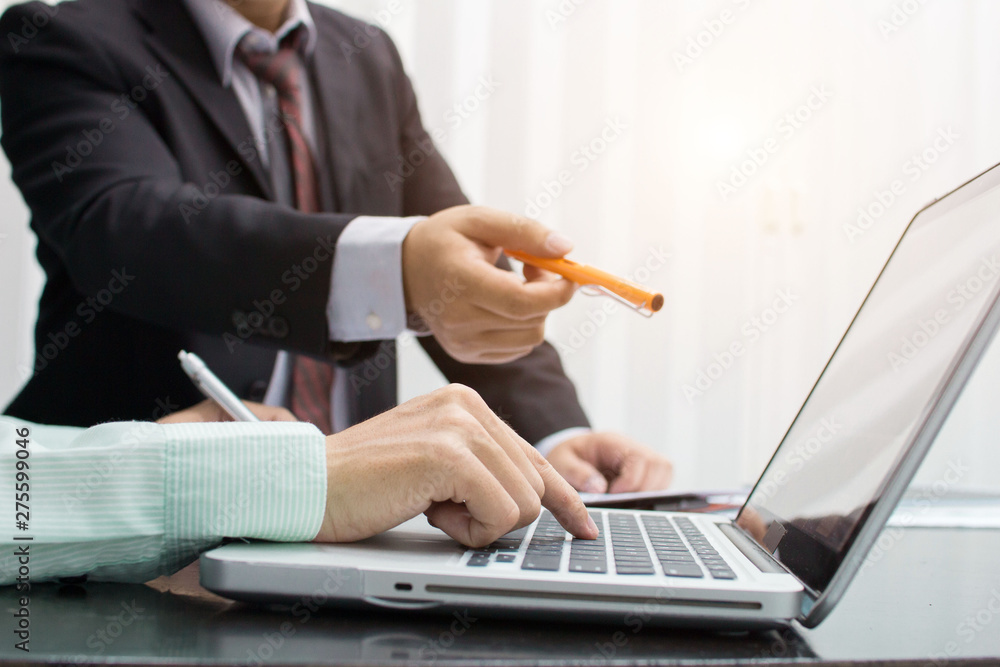 Business man working at office with laptop, tablet and graph data documents on his desk.