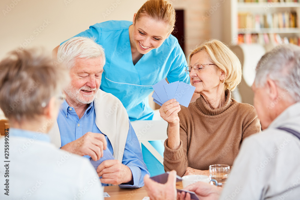 Nursing lady looks on while playing cards Nursing lady looks on while playing cards