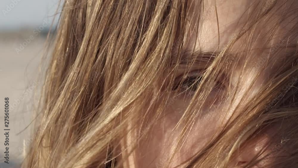 Super close up of a blonde girl with hairs on her face facing camera with sad eyes. Flat plane. Slow motion Super close up of a blonde girl with hairs on her face facing camera with sad eyes. Flat plane. Slow motion