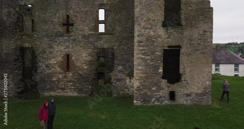 Caislean Rath Bhoth (Raphoe Castle, Bishops Palace), Slow Aerial pullback revealing ancient structure with tourists walking around grounds photo