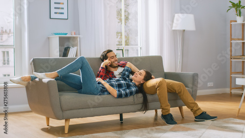 Happy Young Couple is Lying on a New Couch in the Living Room and Having a Rest. Bright Modern Apartment with Stylish Furniture.