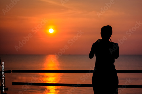 silhouette woman traveler take a photo sunset