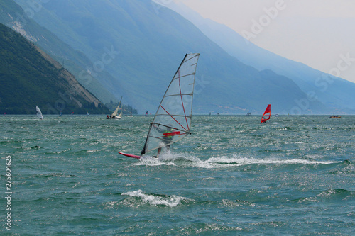 Windsurfer wearing required safety vest at Lake Garda glistening in the sun (Torbole, Italy)