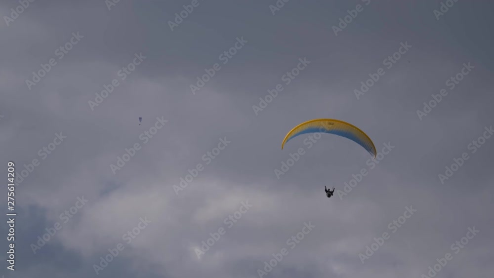 Paraglider flying against a cloudy sky Paraglider flying against a cloudy sky