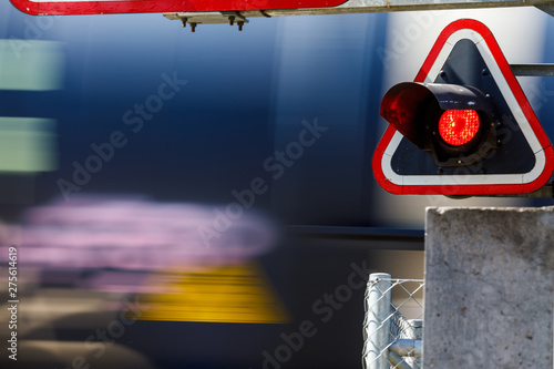 Fotografie A train passing across a level crossing, on small road