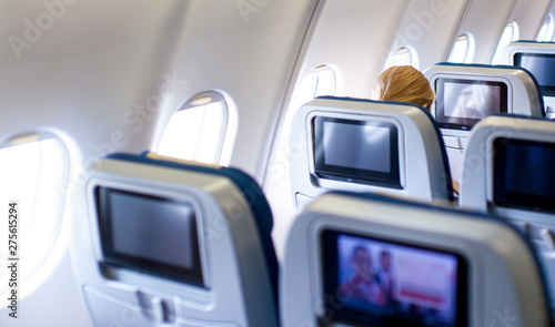 The people looking for their LCD screens displays on airplane seat monitors. The interior of modern economy class in airplanes.