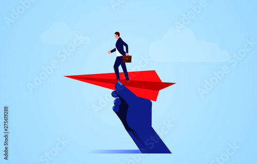 Help take off, huge hand holding paper plane and take off with businessman