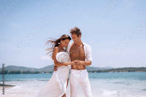 Tableau sur toile romantic  young couple in white clothes  enjoying summer vacation  on the beach