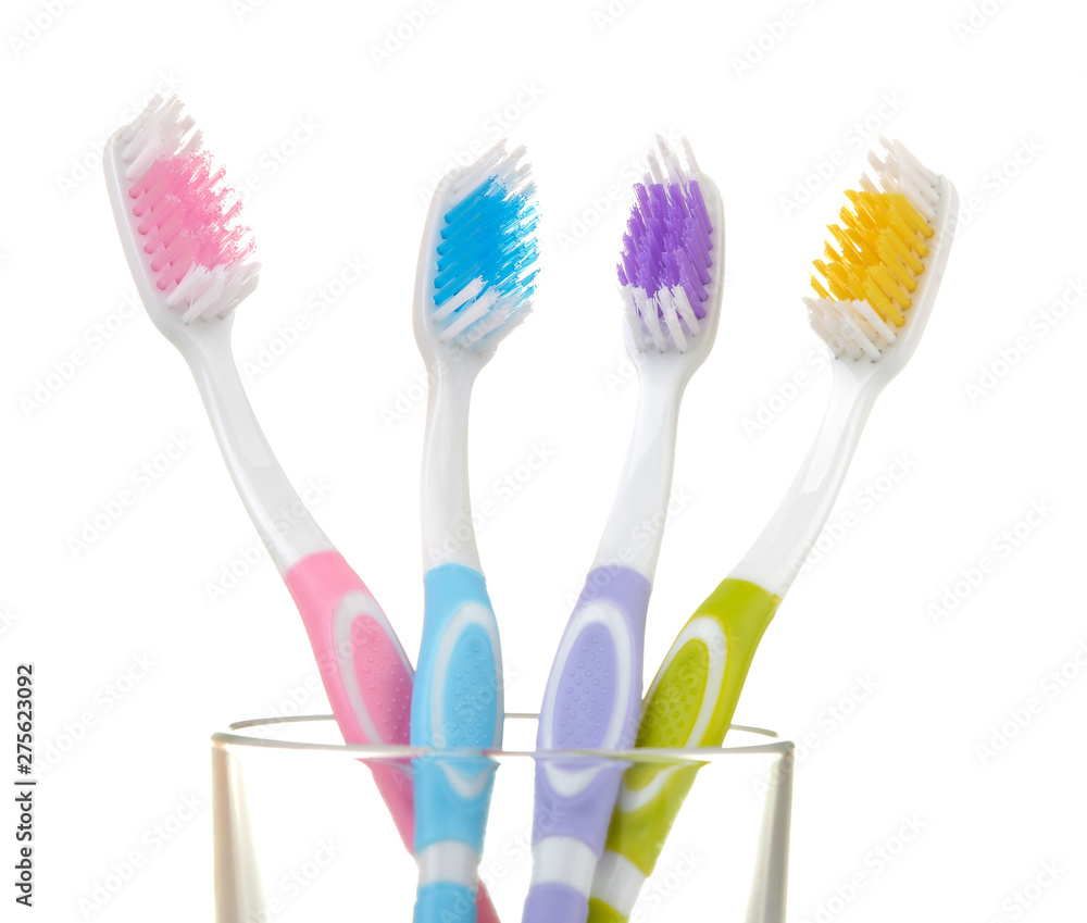 Multi-colored toothbrushes in a glass beaker on a white isolated background. Oral hygiene. Multi-colored toothbrushes in a glass beaker on a white isolated background. Oral hygiene.