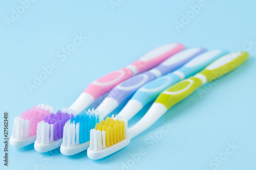Oral hygiene. Multi-colored toothbrush on a gentle blue background. space for text