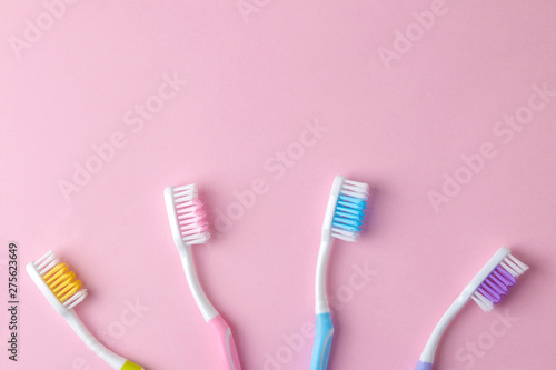 Oral hygiene. Multi-colored toothbrush on a bright pink background. top view. space for text