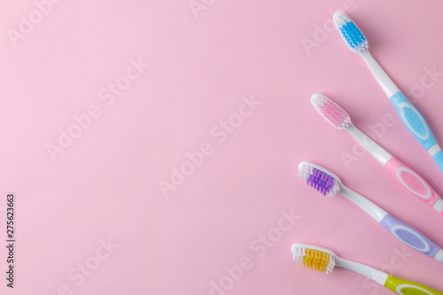 Oral hygiene. Multi-colored toothbrush on a bright pink background. top view. space for text