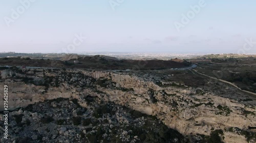 Astonishing aerial view of Dingli Cliffs, Malta, approached by drone from the seaside, revealing  the road Triq Il-Panoramica and Limestone quarry photo