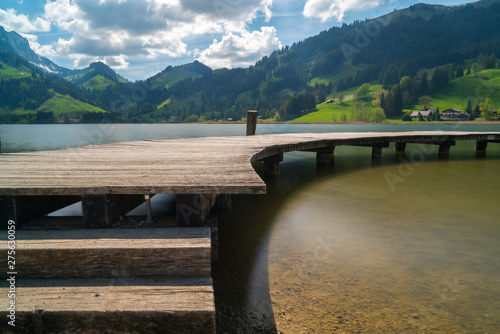 long wooden boardwalk on a calm and placid mountain lake with a great view