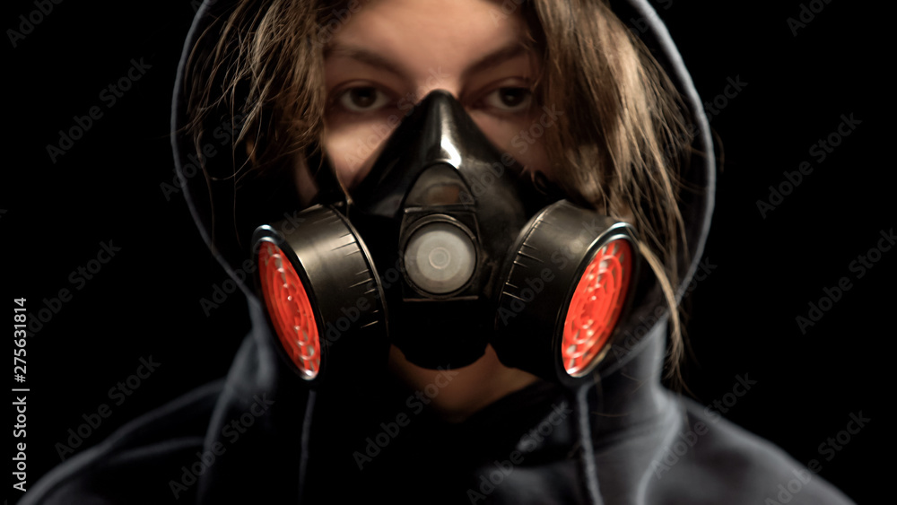 Female in respirator on dark background, protection from gas attack, closeup Female in respirator on dark background, protection from gas attack, closeup