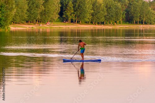 Image of stand up paddleboarding man on a lake
