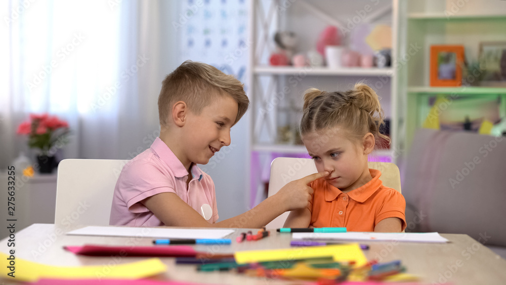 Naklejka premium Playful brother touching sisters nose, children communication, apologizing