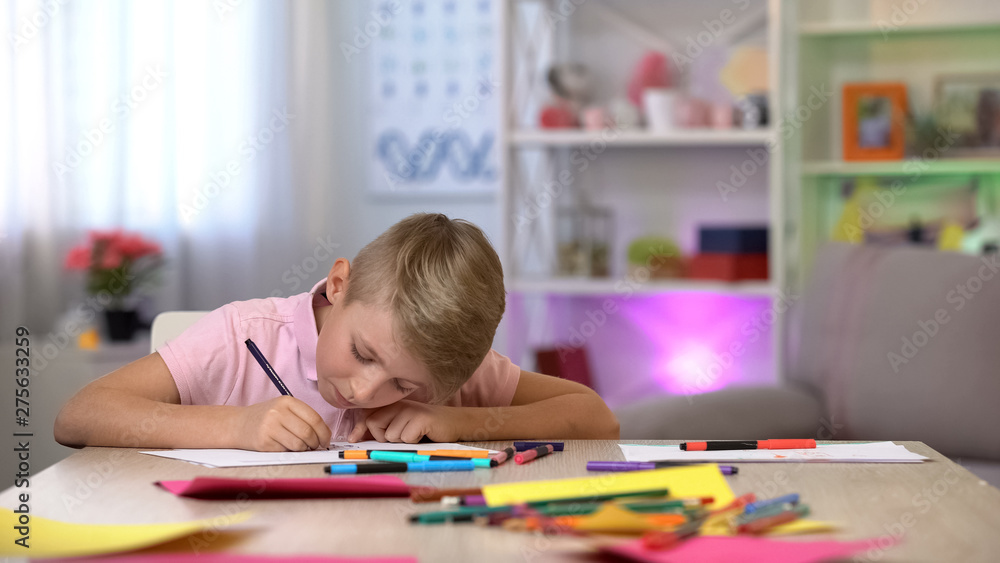 Concentrated boy drawing picture, spending free time, art school lesson, hobby Concentrated boy drawing picture, spending free time, art school lesson, hobby