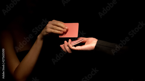 Male holding deck, woman choosing card, illusionist show, magic trick close up