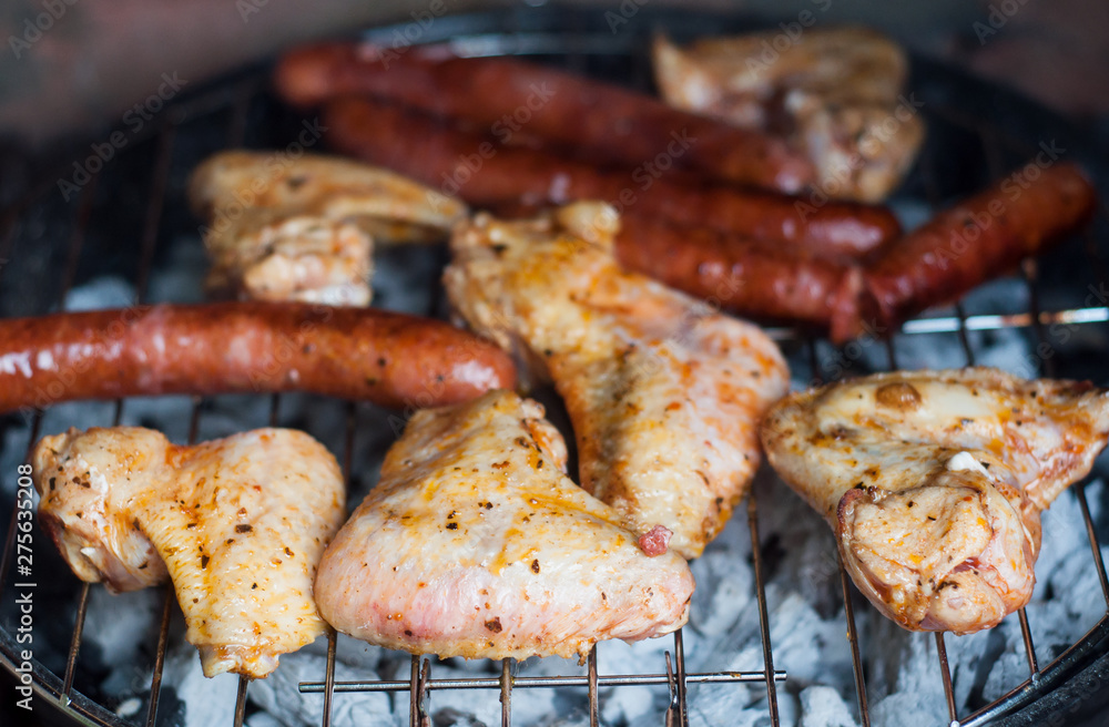 closeup of sausages and chicken  on the barbecue