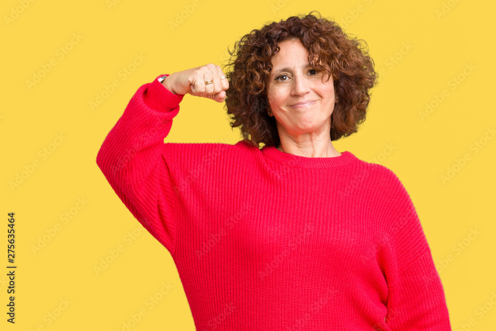 Beautiful middle ager senior woman red winter sweater over isolated background Strong person showing arm muscle, confident and proud of power Beautiful middle ager senior woman red winter sweater over isolated background Strong person showing arm muscle, confident and proud of power