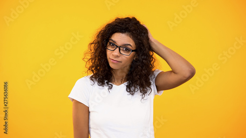 Pensive biracial woman touching back of head, unsure of choice, making decision