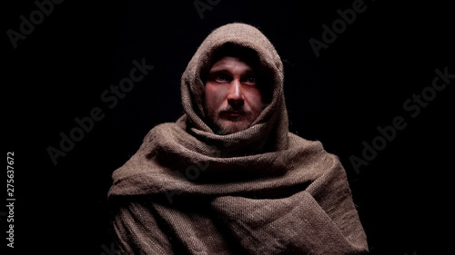 Photo Poor male in rough robe looking directly to camera, early christian prophet