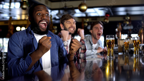 Emotional african-american male celebrating favorite team victory, rest in bar