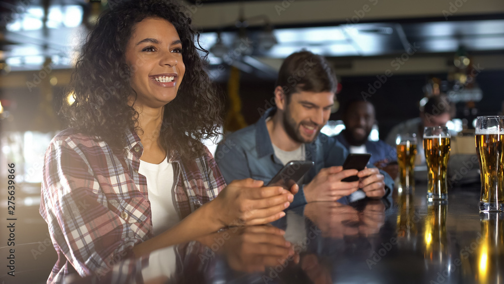 Joyful female happy about winning bet on sports game in pub, celebrating victory Joyful female happy about winning bet on sports game in pub, celebrating victory