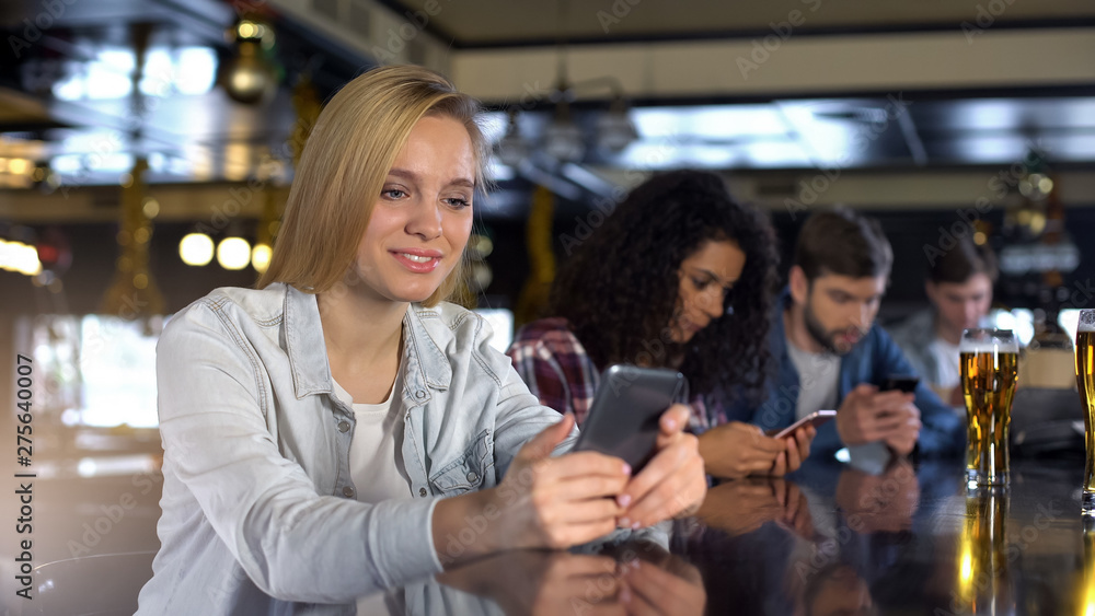 Group of people using phones in bar, addicted to social networks millennials