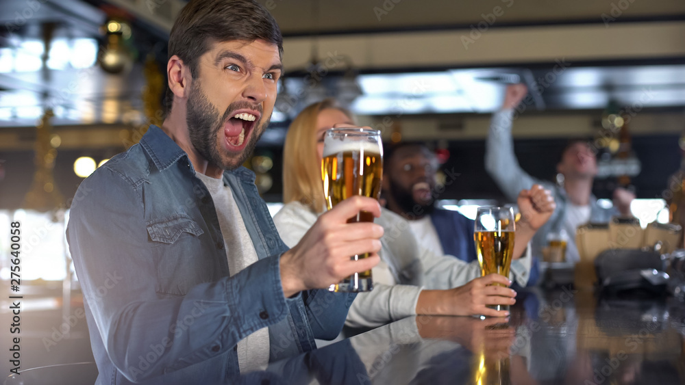 Overemotional caucasian make cheering for favorite team with friends in bar