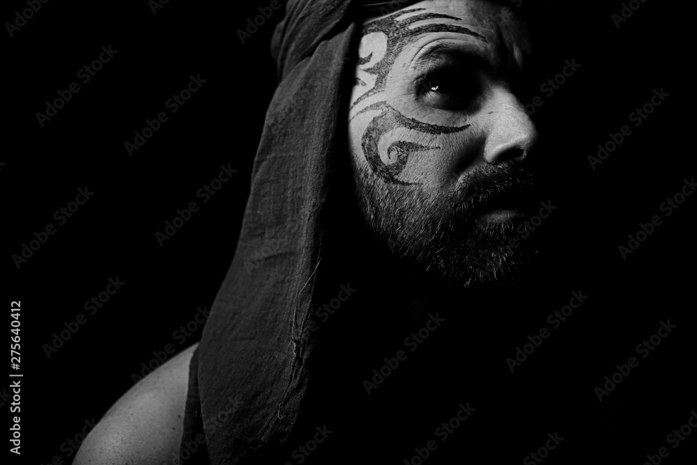 tattoo on the face, male portrait in the form of an assassin, cosplay, tattooed brutal man, guy with a tattooed face tattoo on the face, male portrait in the form of an assassin, cosplay, tattooed brutal man, guy with a tattooed face
