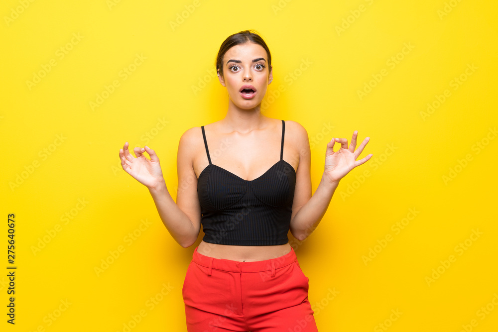 Young woman over isolated yellow background with shocked facial expression Young woman over isolated yellow background with shocked facial expression