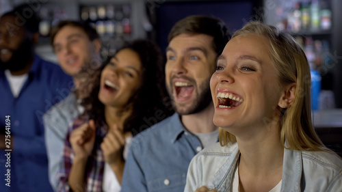 Extremely happy girl enjoying match with friends  celebrating team victory