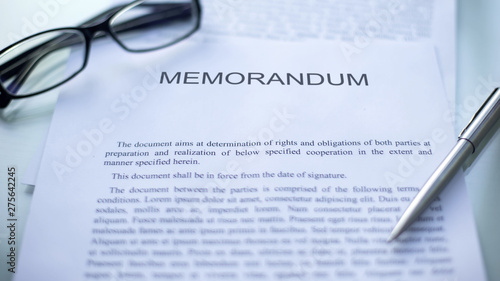 Memorandum lying on table, pen and eyeglasses on official document, business