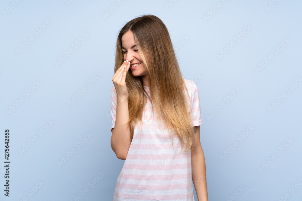 Young woman over isolated blue background smiling a lot Young woman over isolated blue background smiling a lot