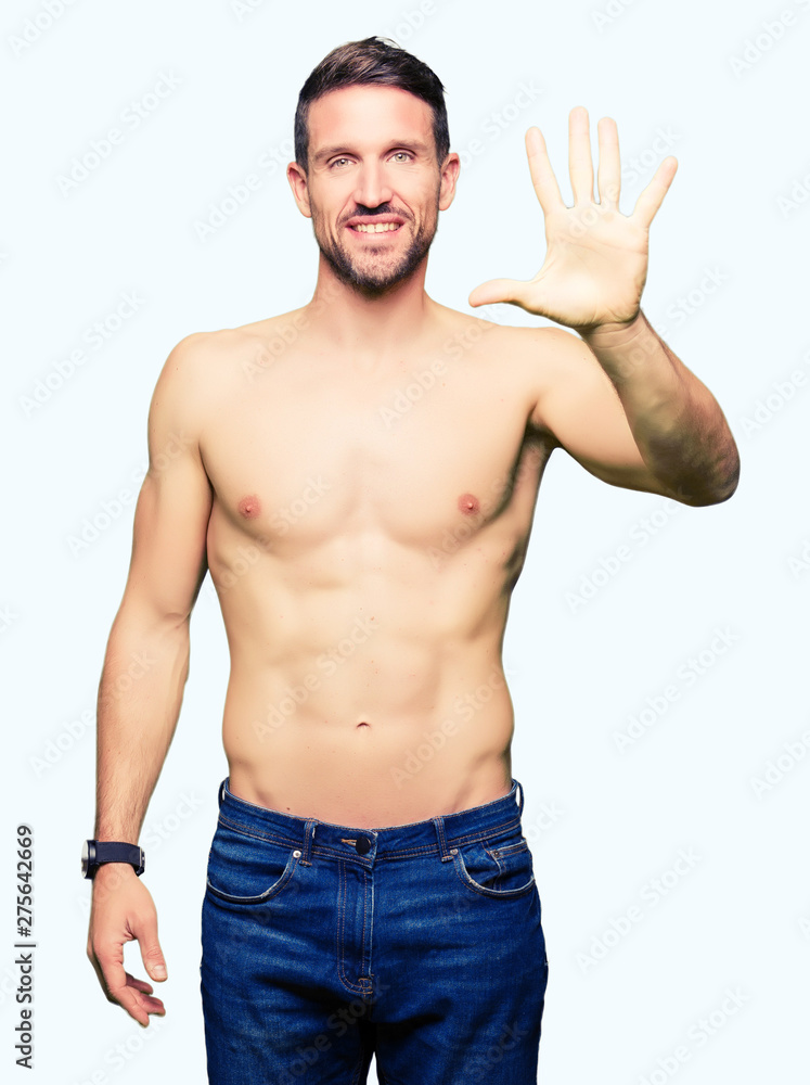 Fototapeta premium Handsome shirtless man showing nude chest showing and pointing up with fingers number five while smiling confident and happy.