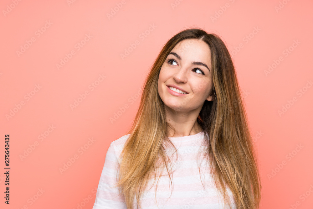 Young woman over isolated pink wall laughing and looking up Young woman over isolated pink wall laughing and looking up