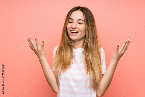 Young woman over isolated pink wall laughing